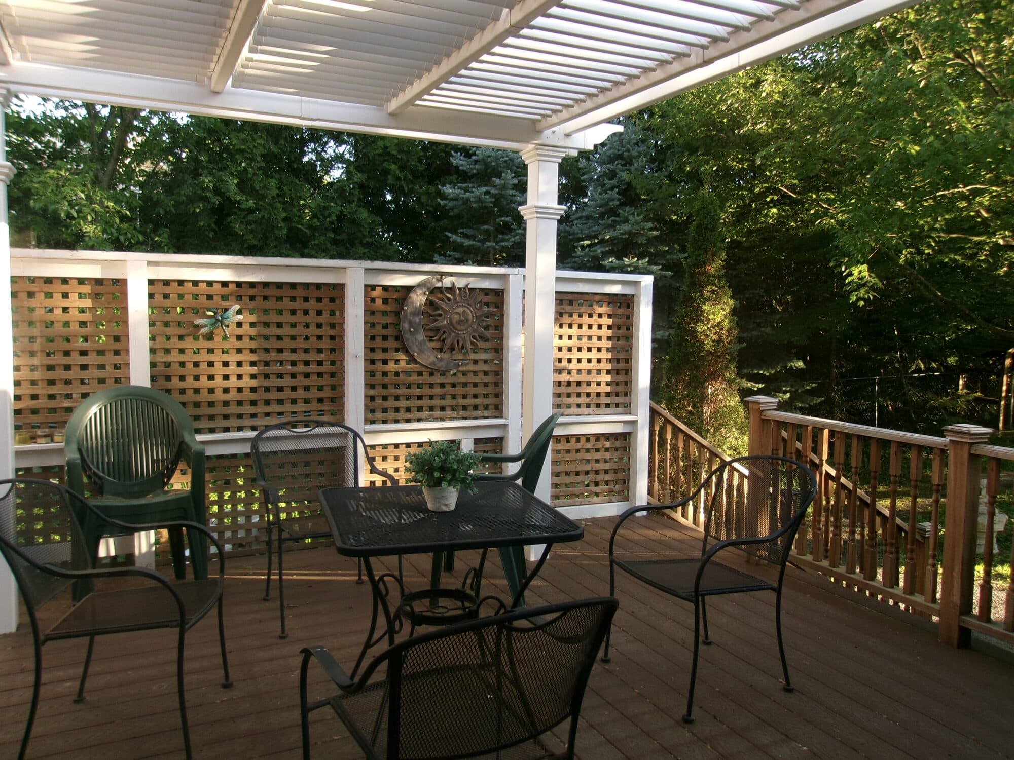 Outdoor deck with seating under a pergola after VelocityMaid property care in Middlebury