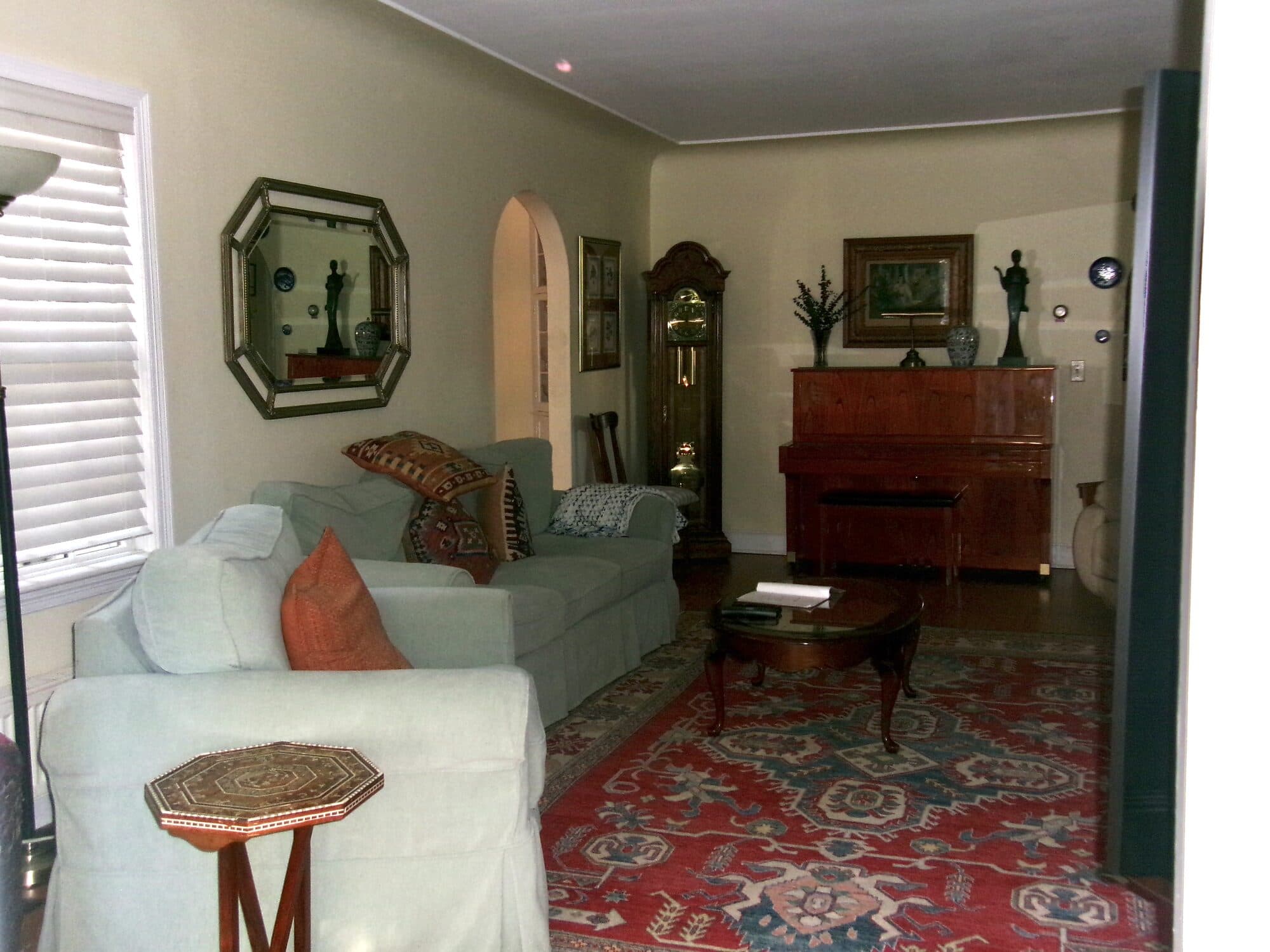 Formal living room with sofa and piano after VelocityMaid property care in Middlebury