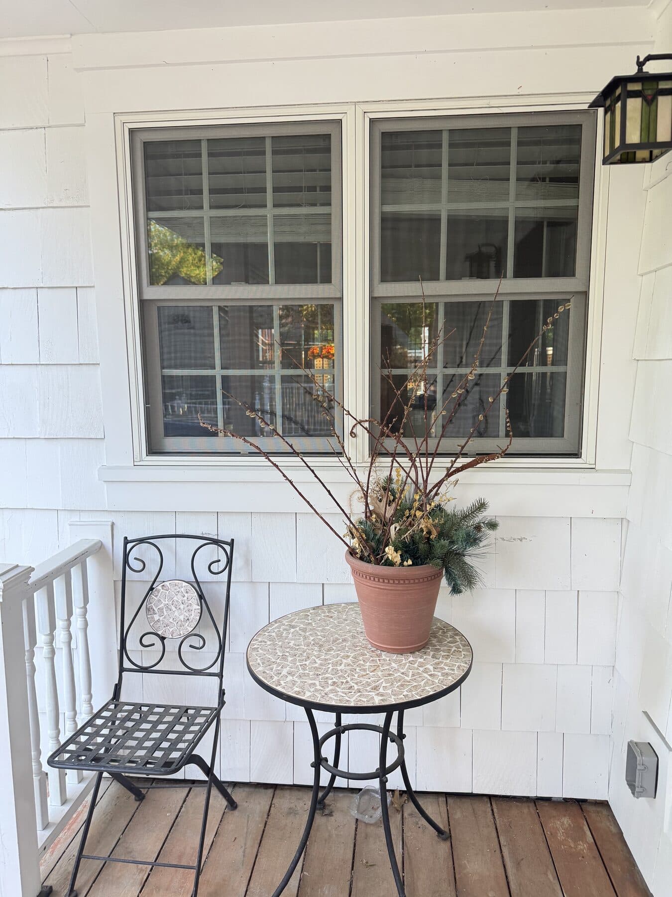 Covered porch with a chair, table, and planter after VelocityMaid property care in Middlebury