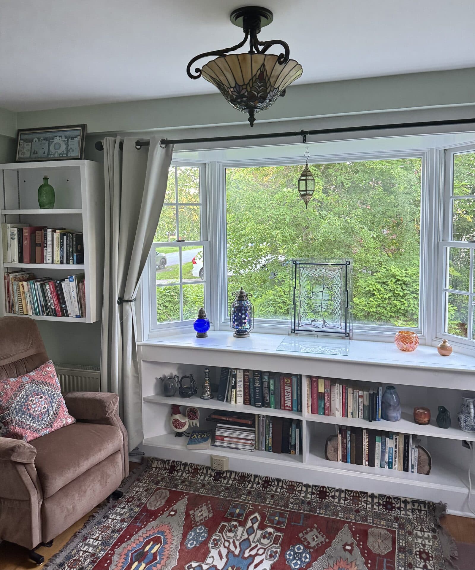 Reading room with bay window, bookshelves, and clear surfaces after VelocityMaid care in Middlebury